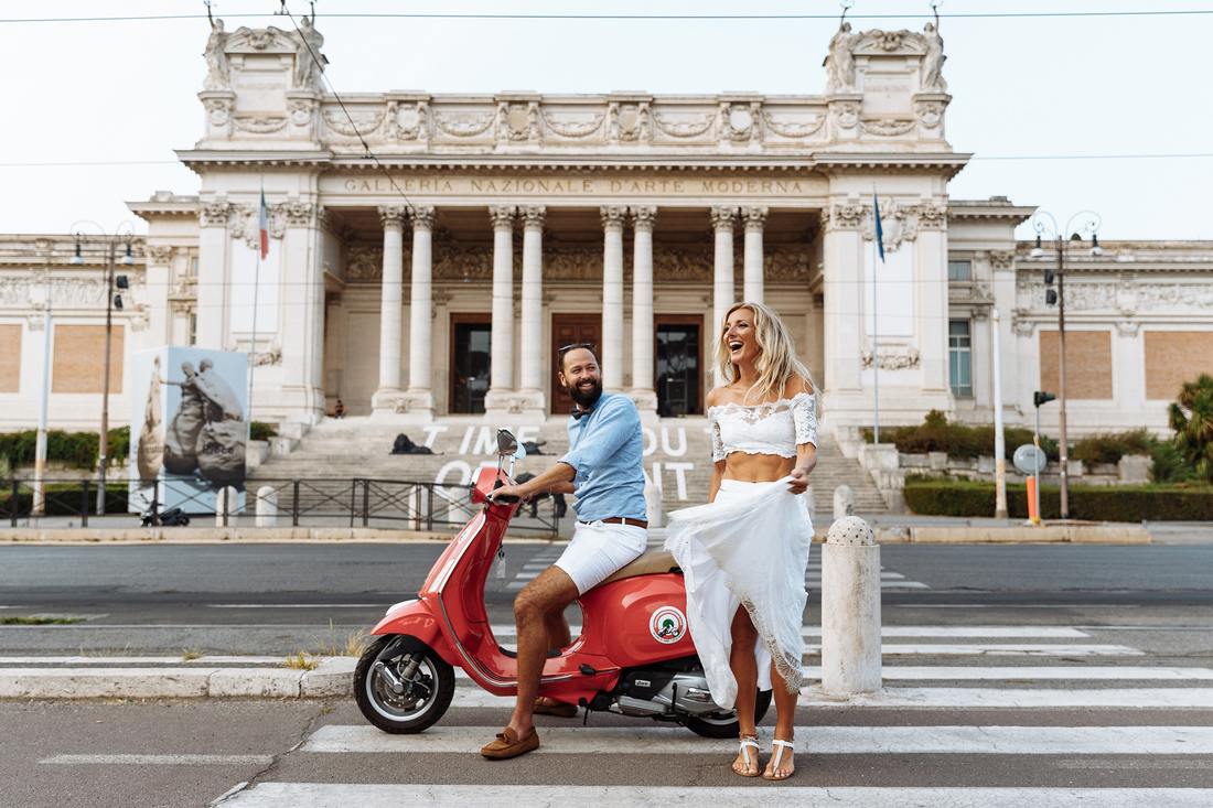 man on red scooter, woman in white 