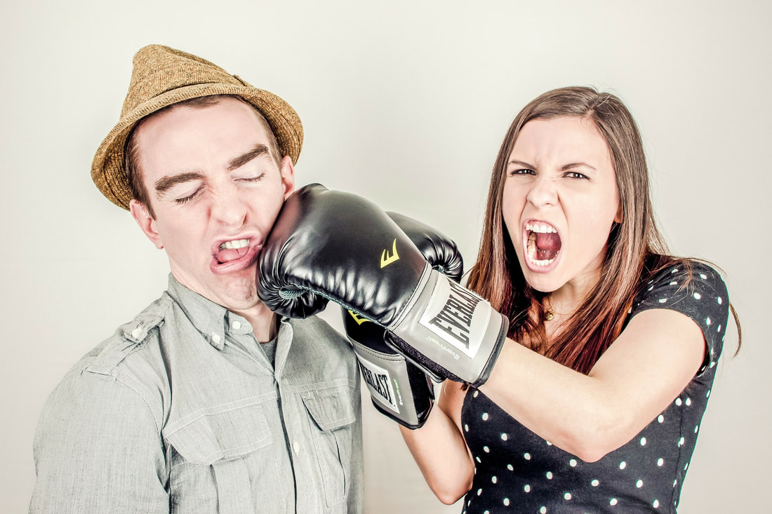 woman wearing boxing gloves punching a man