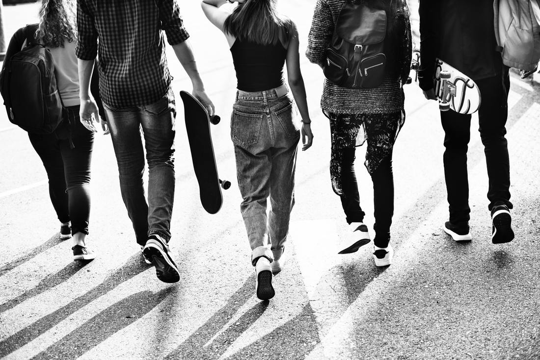  teenagers walking with skateboards