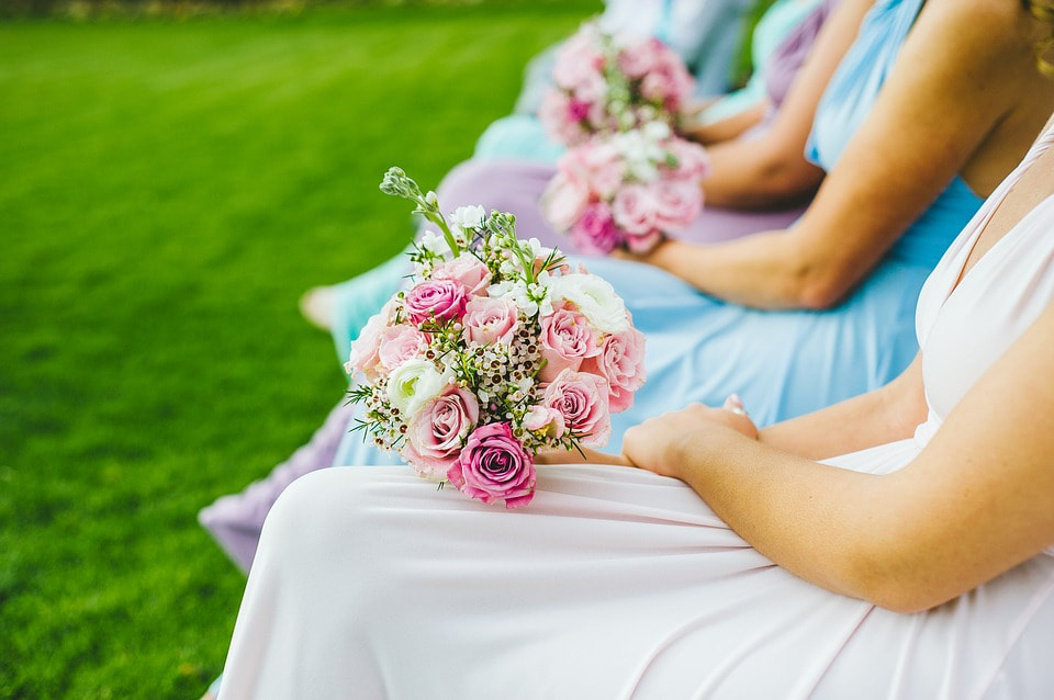 bridesmaids sitting pink and blue dresses, pink rose bouquet