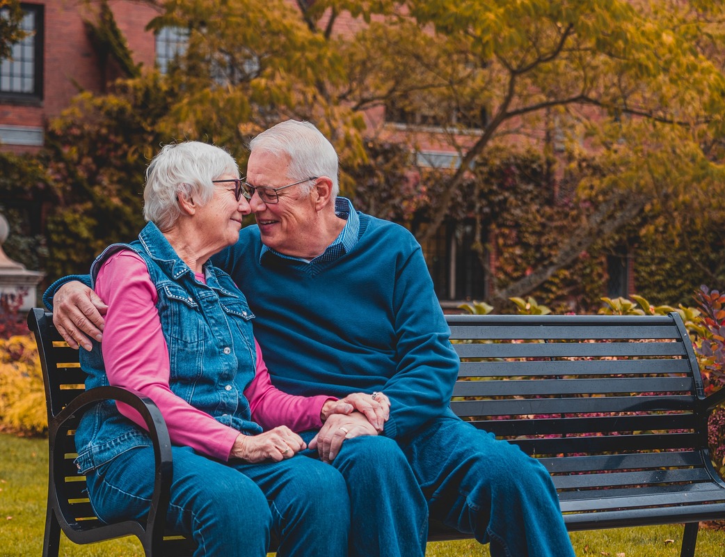 older couple sitting holding hands 