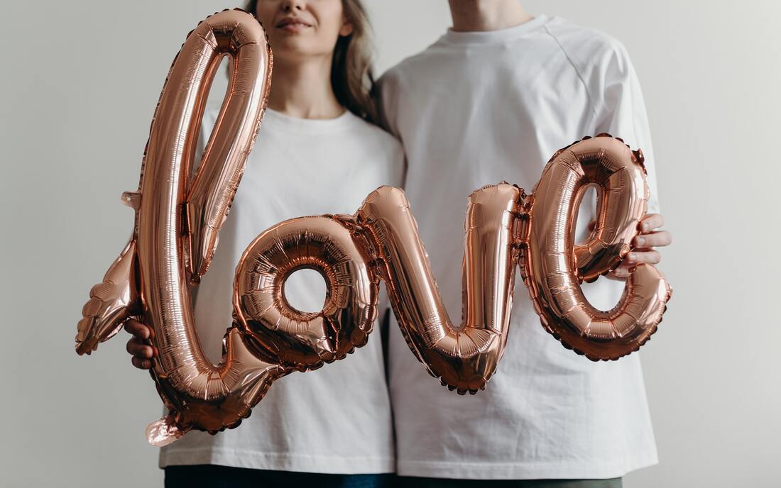 couple holding love balloons